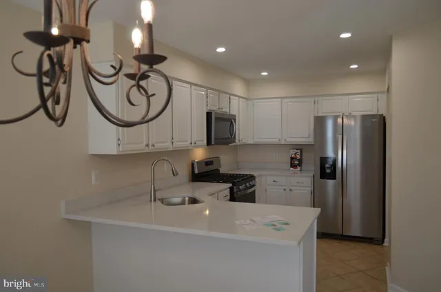 a kitchen with stainless steel appliances a sink cabinets and a refrigerator