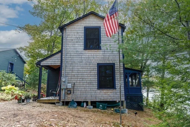 a view of a house with a yard and potted plants