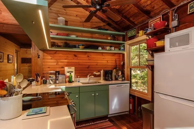 a room with stainless steel appliances kitchen island granite countertop a refrigerator and a stove