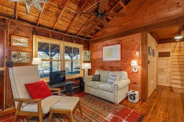 a living room with furniture a wooden floor and next to a window