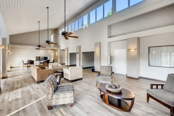 a living room with furniture kitchen view and a chandelier