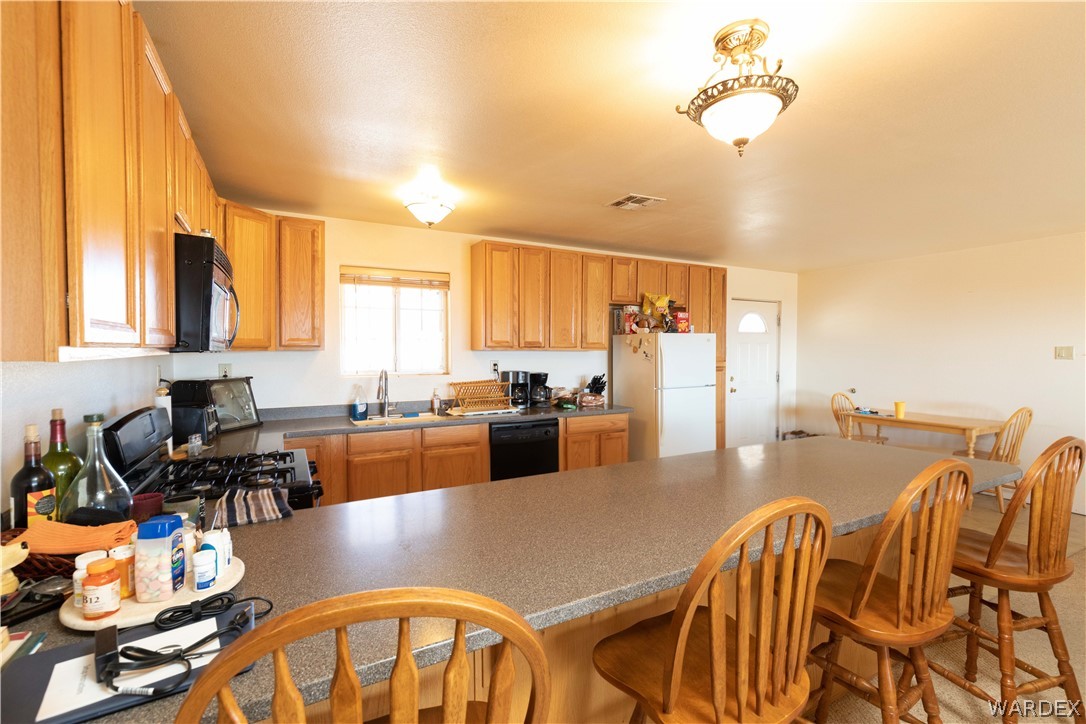 2136 Dewey Road Golden Valley, AZ 86413 - Photo 12 of 44 a kitchen with stainless steel appliances granite countertop a table chairs and a refrigerator
