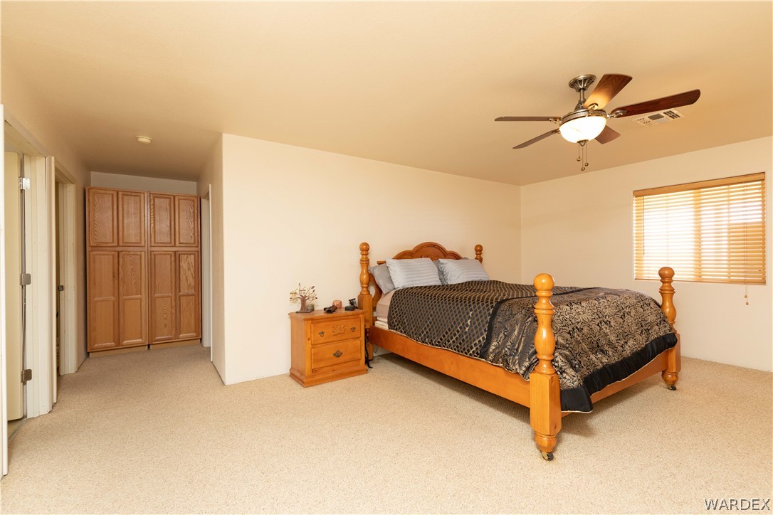 2136 Dewey Road Golden Valley, AZ 86413 - Photo 14 of 44 a bed room with a bed and a chandelier