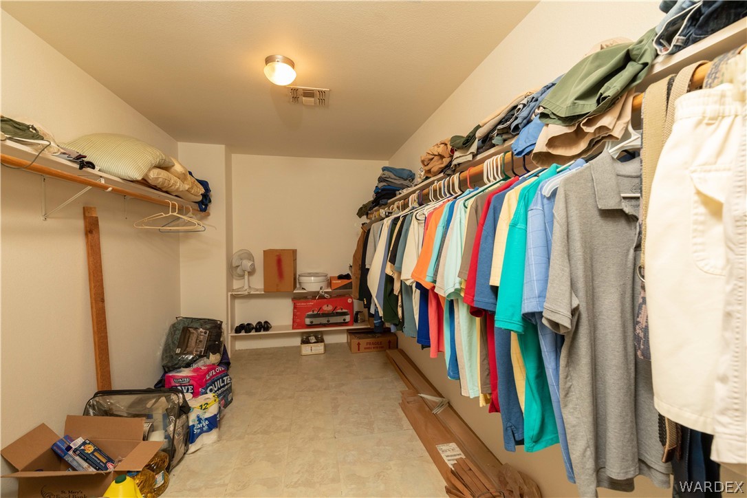 2136 Dewey Road Golden Valley, AZ 86413 - Photo 17 of 44 a view of walk in closet with clothes and shoes