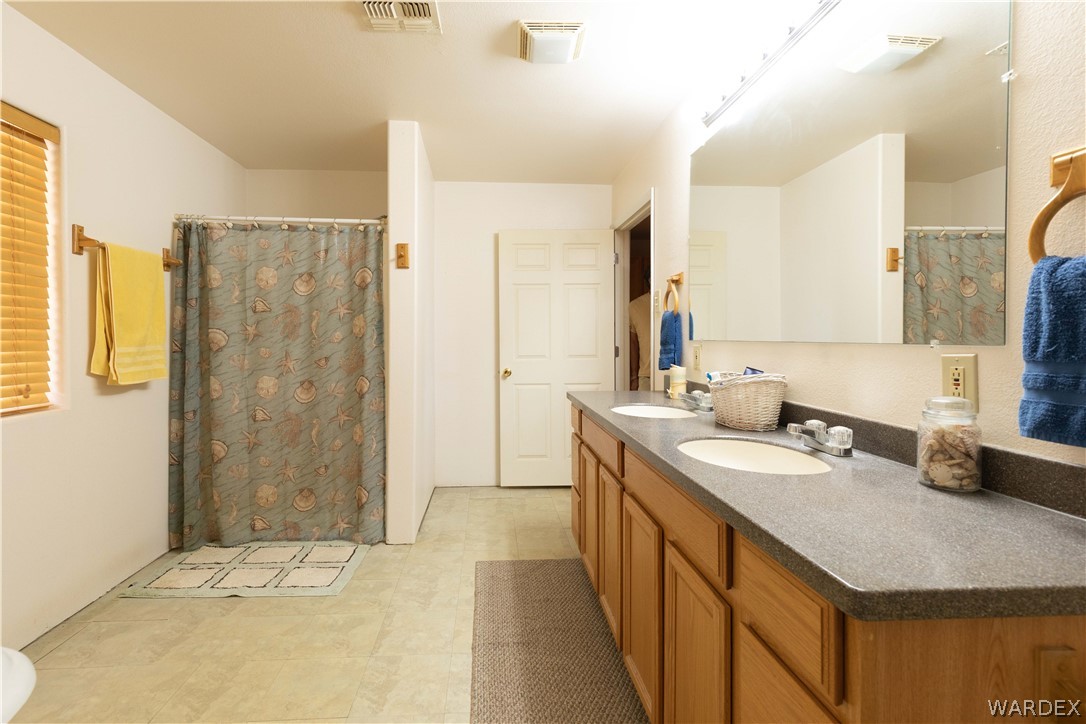 2136 Dewey Road Golden Valley, AZ 86413 - Photo 19 of 44 a bathroom with double vanity and a shower