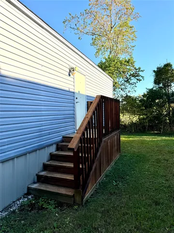 a view of a house with backyard and wooden deck