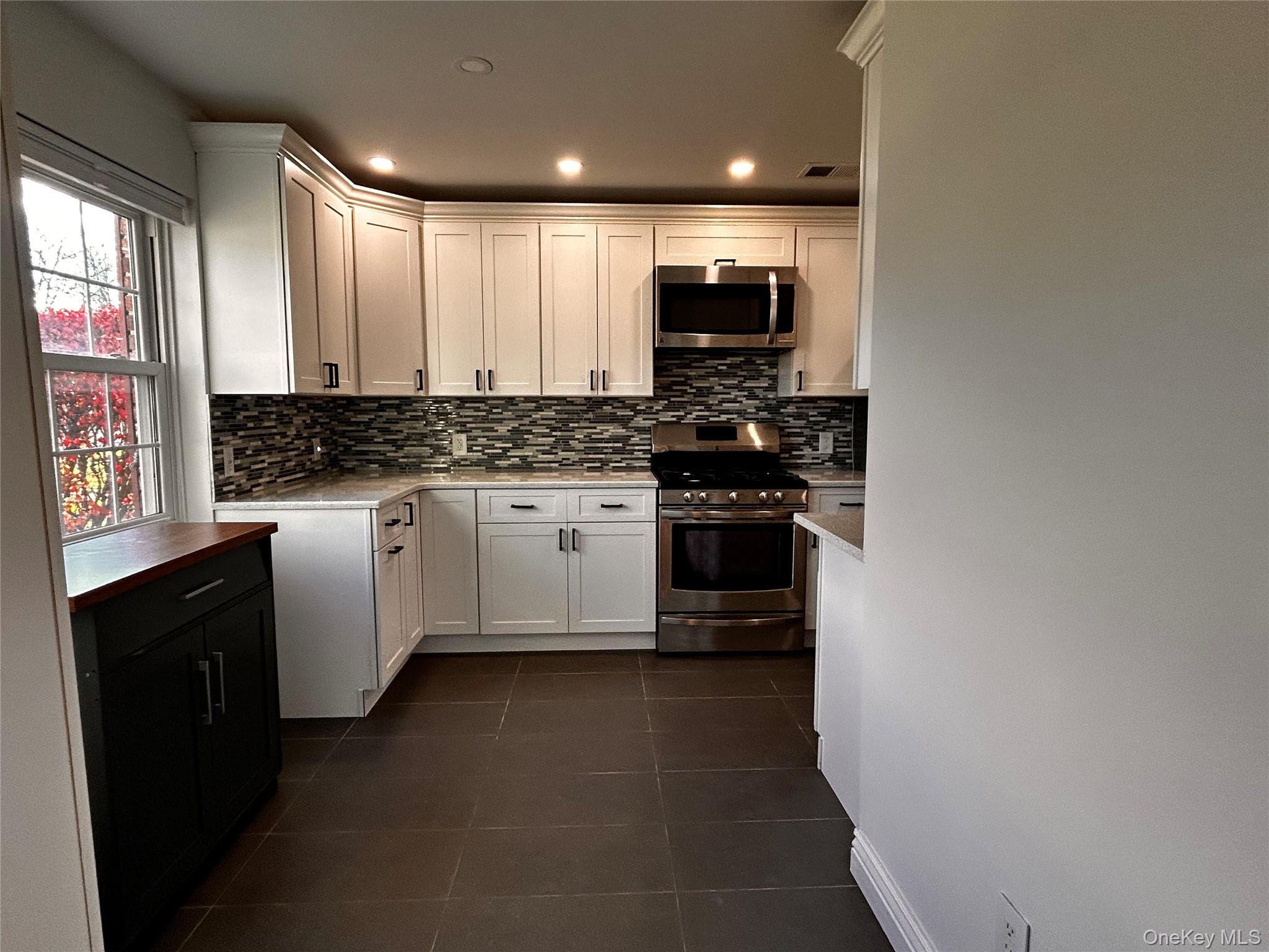 a kitchen with stainless steel appliances a sink stove and cabinets