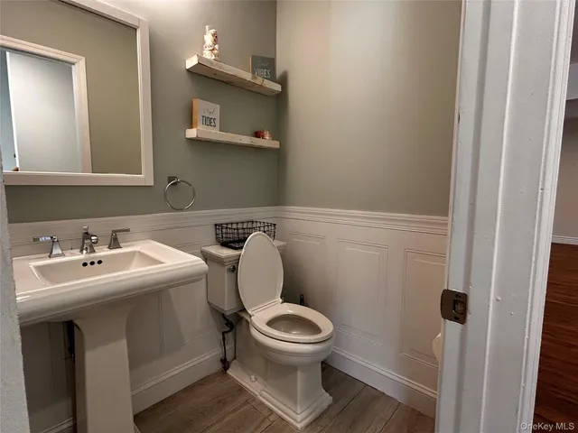 a bathroom with a toilet a sink and mirror