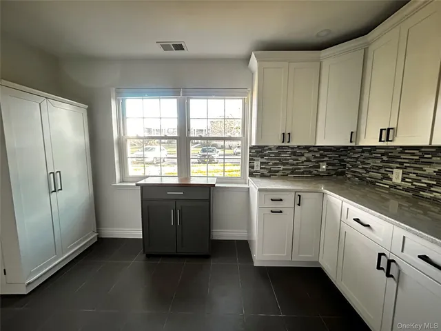 a kitchen with stainless steel appliances white cabinets and a window