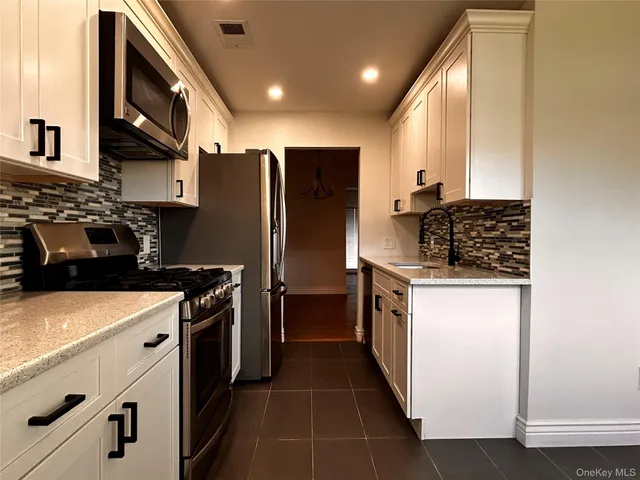 a kitchen with stainless steel appliances granite countertop a refrigerator and a stove