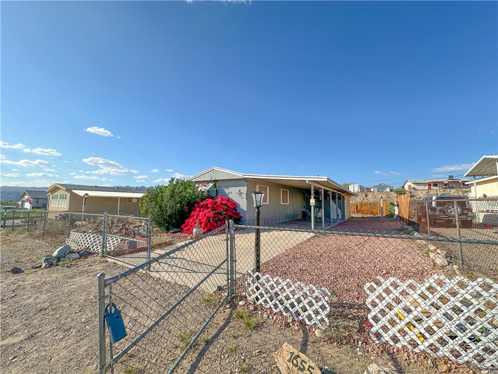 1655 Ramar Road Bullhead City, AZ 86442 - Photo 2 of 49 View of front of property with a fenced front yard, double gates- RV Parking, and a carport