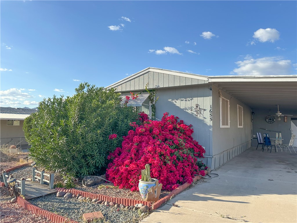 1655 Ramar Road Bullhead City, AZ 86442 - Photo 3 of 49 View of property exterior featuring a carport, concrete driveway, and a patio area