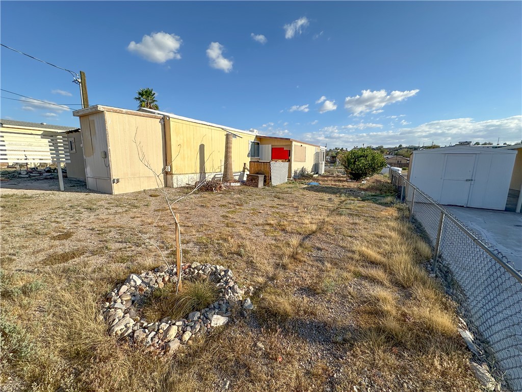 1655 Ramar Road Bullhead City, AZ 86442 - Photo 35 of 49 Fenced yard featuring a shed