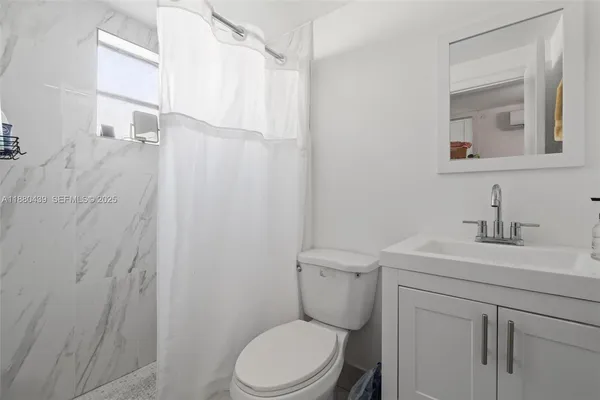 a bathroom with a toilet a sink a vanity and mirror