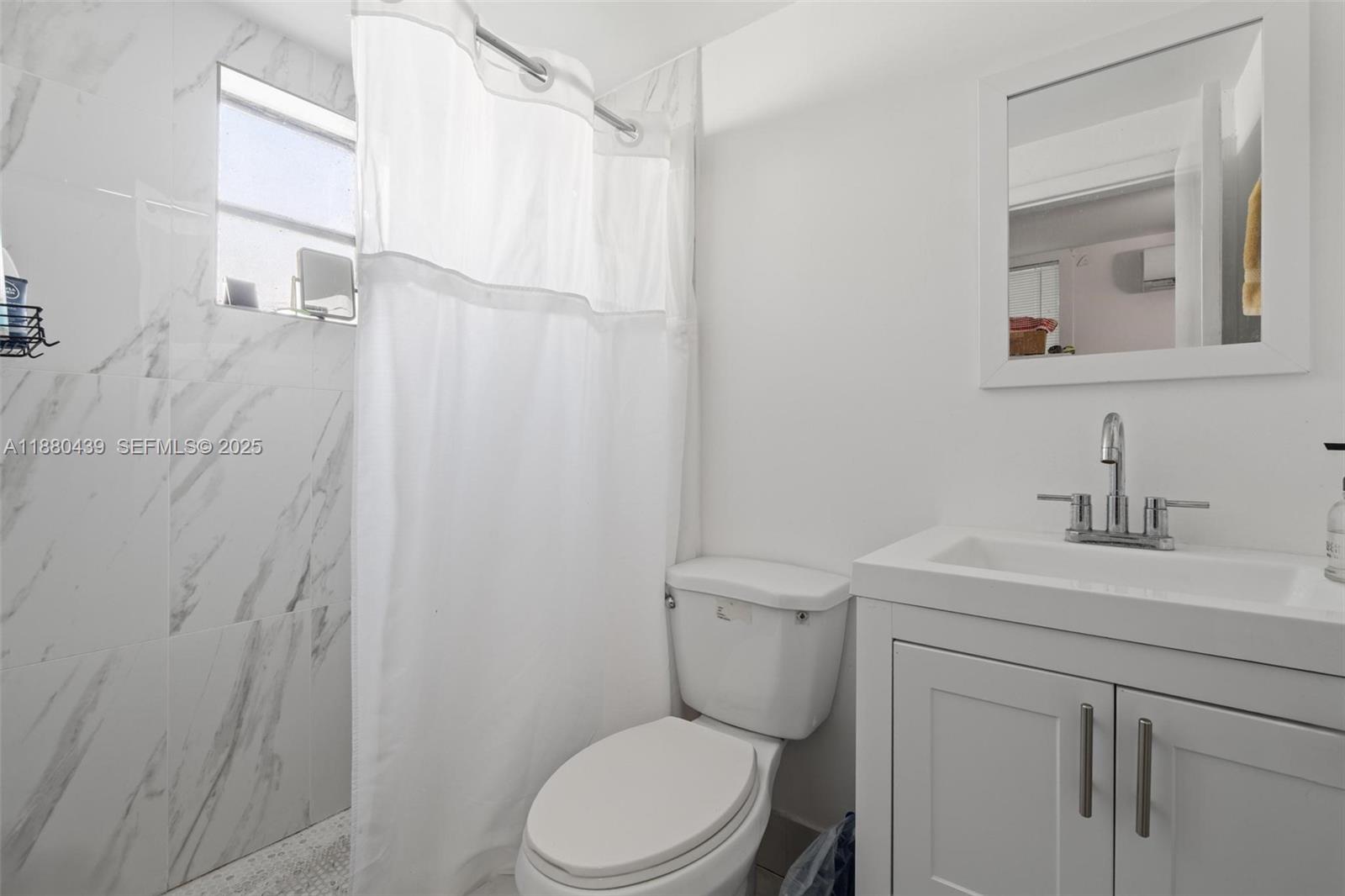 2453 Southwest 17th Street, Unit 2 Miami, FL 33145 - Photo 6 of 7 a bathroom with a toilet a sink a vanity and mirror