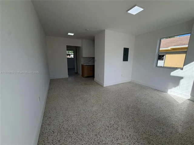 an empty room with windows and cabinet