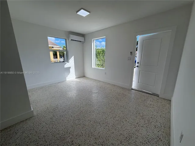 an empty room with windows and cabinet