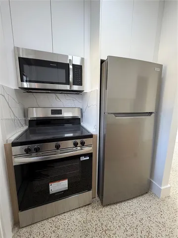 a stove top oven sitting inside of a kitchen