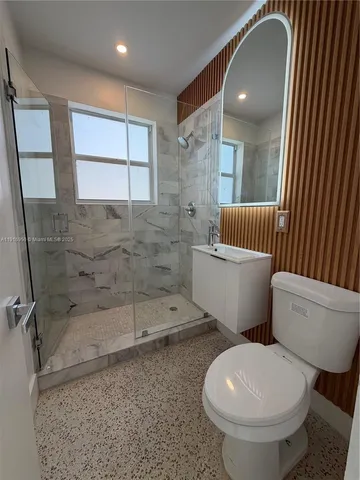 a white toilet sitting next to a bathroom sink