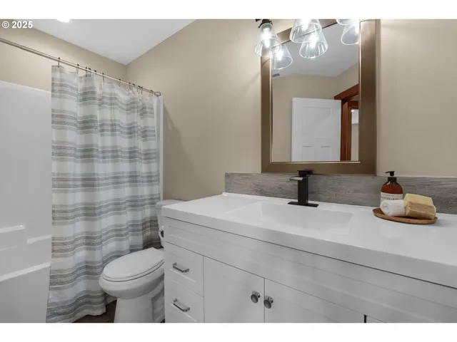 a bathroom with a sink a toilet and a mirror