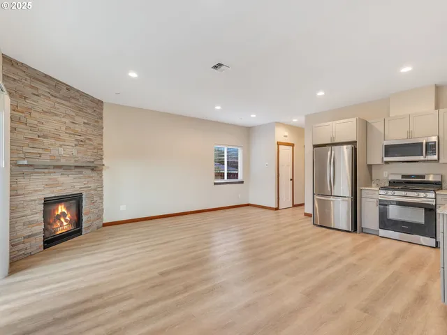 a view of kitchen with a sink fire place and wooden floor