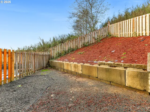 a view of a backyard with wooden fence