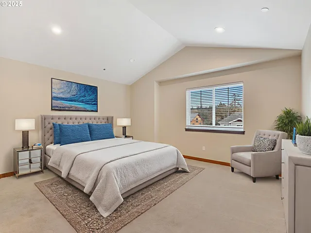 a bedroom with a large bed couch and a potted plant