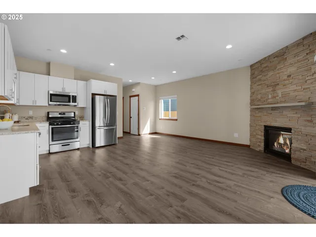 a view of a kitchen with a sink stove cabinets and empty room