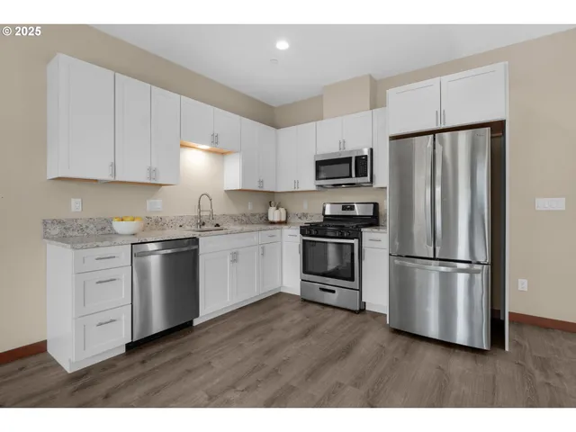 a kitchen with a refrigerator stove and white cabinets