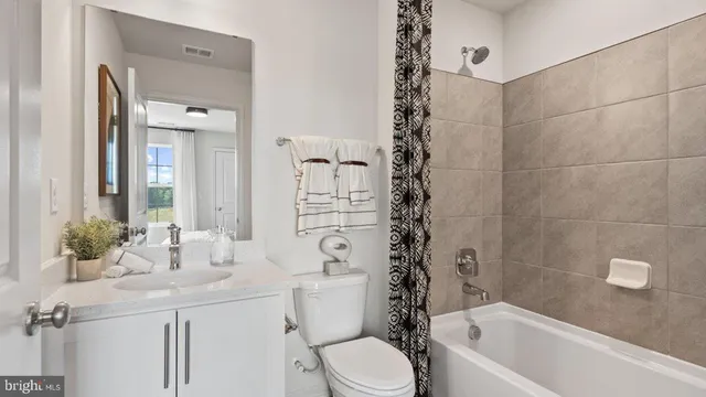 a bathroom with a sink a toilet a mirror a vanity and shower