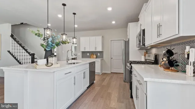 a kitchen with kitchen island a sink appliances and cabinets