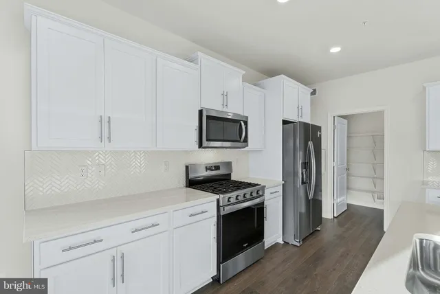 a kitchen with stainless steel appliances a refrigerator stove and microwave