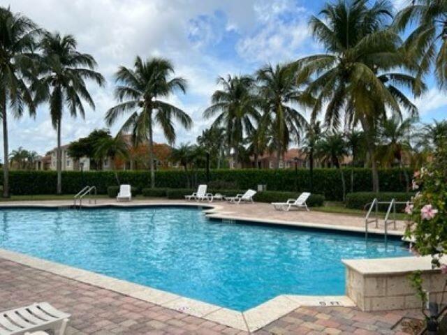 7848 Sonoma Springs Circle, Unit 202 Lake Worth, FL 33463 - Photo 14 of 16 a view of a swimming pool with a garden and trees