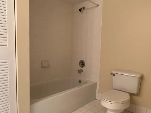 a white toilet sitting next to a bath tub