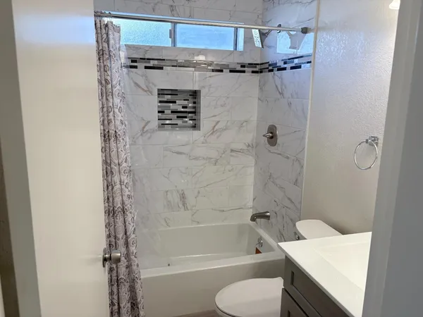 a bathroom with a shower toilet and sink