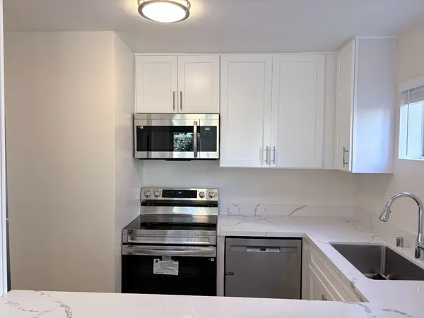 a kitchen with stainless steel appliances a sink a stove and cabinets