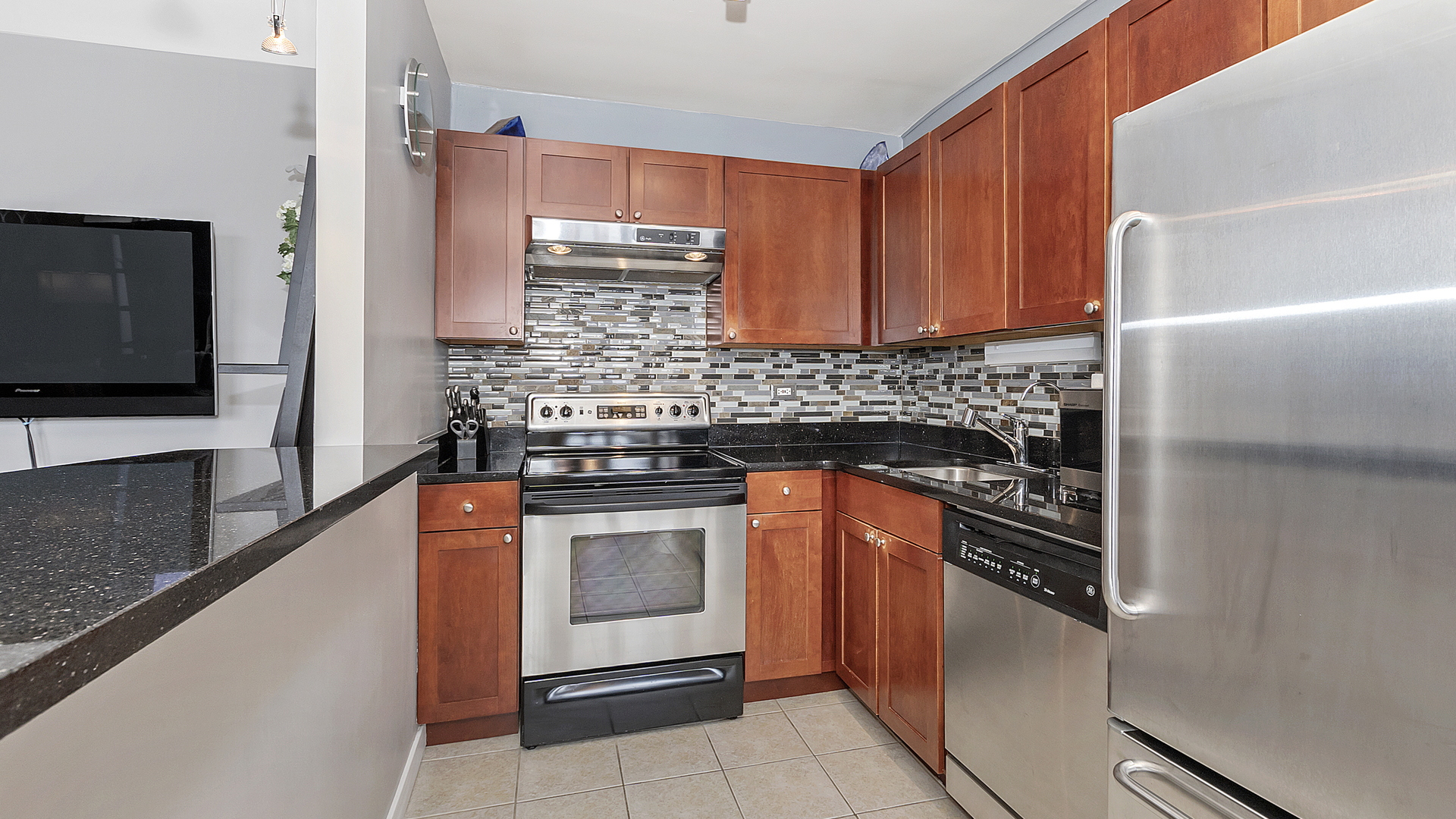 655 West Irving Park Road, Unit 915 Chicago, IL 60613 - Photo 6 of 18 a kitchen with stainless steel appliances granite countertop a stove microwave and refrigerator