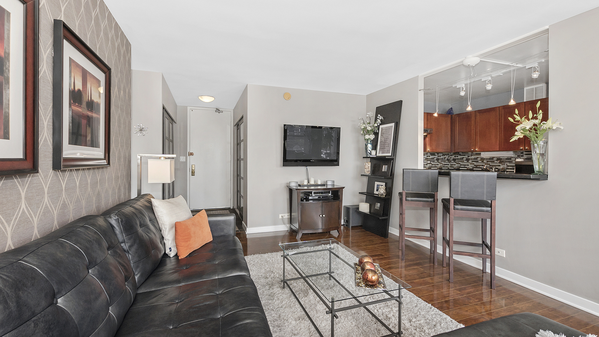 655 West Irving Park Road, Unit 915 Chicago, IL 60613 - Photo 7 of 18 a living room with furniture a flat screen tv and kitchen view