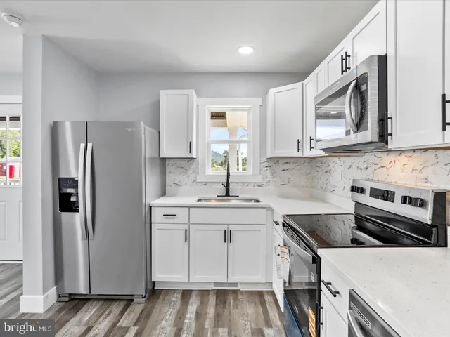 a kitchen with stainless steel appliances a sink stove and refrigerator