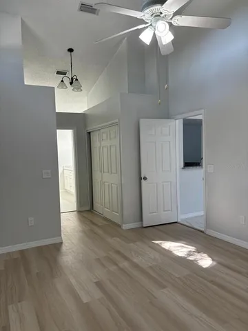 a view of a livingroom with a ceiling fan window and wooden floor