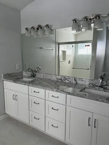 a bathroom with a granite countertop sink double and mirror