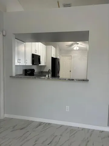 a view of kitchen and microwave with cabinets