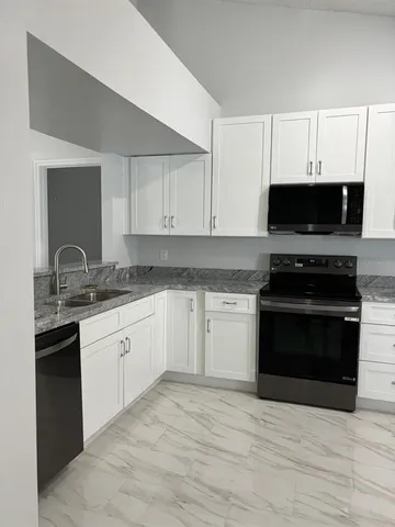 a kitchen with granite countertop a stove and a sink