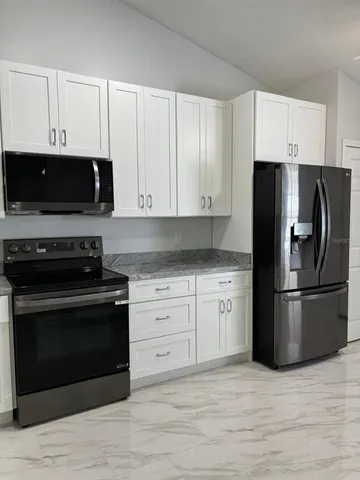 a kitchen with cabinets stainless steel appliances and a wooden floor