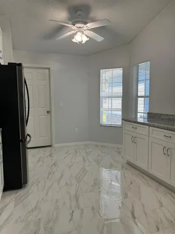 a view of a kitchen with faucet cabinets and stainless steel appliances