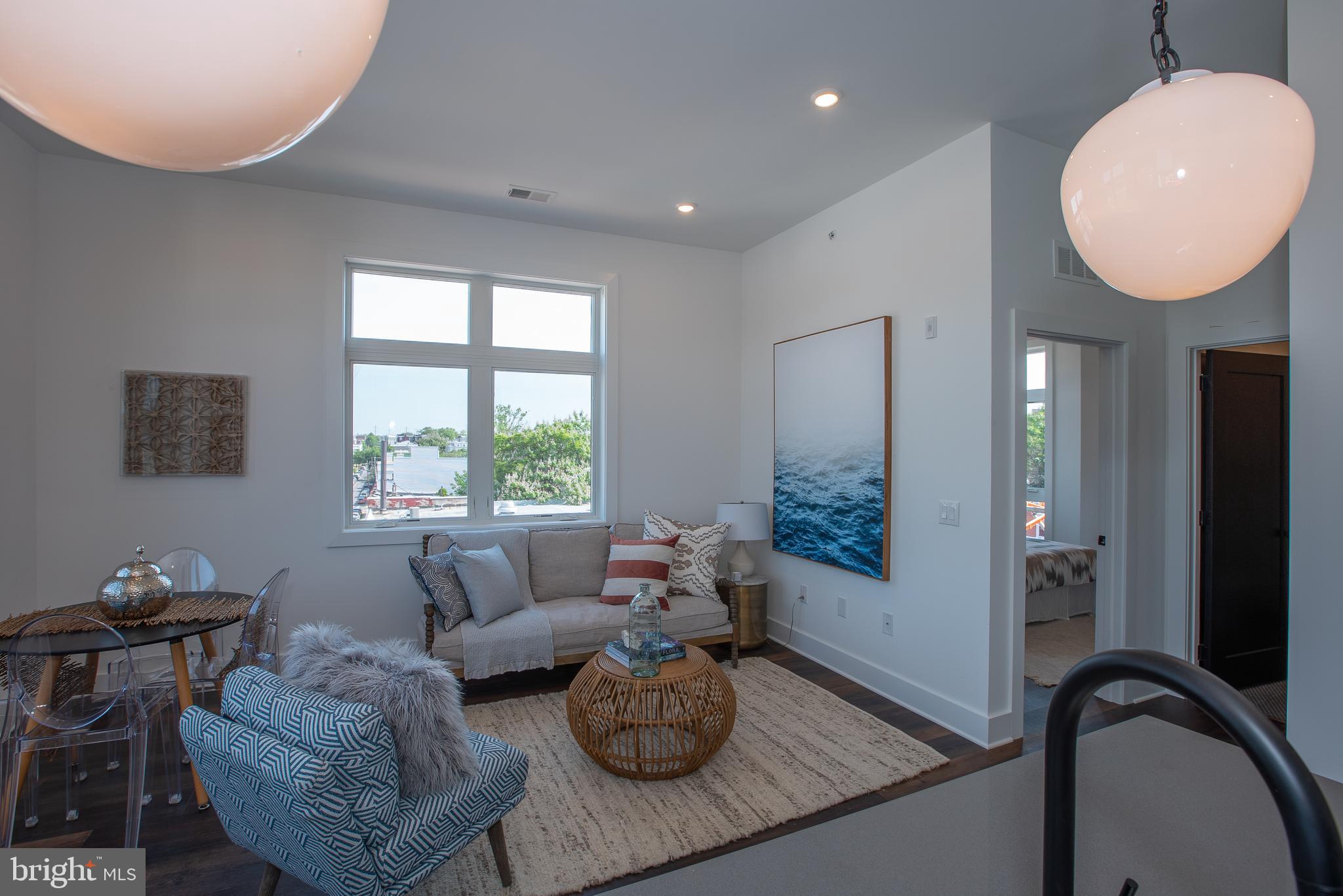 2940 West Thompson Street, Unit 302 Philadelphia, PA 19121 - Photo 15 of 43 a living room with furniture a window and a chandelier