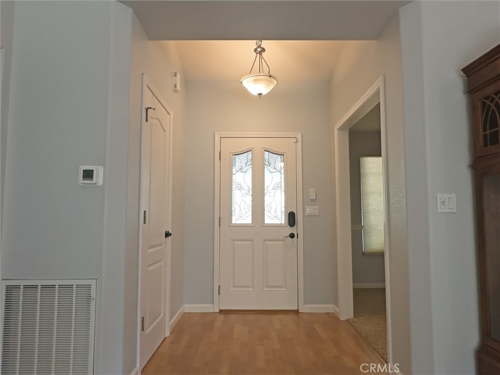 14279 Carnegie Road Magalia, CA 95954 - Photo 5 of 38 a view of a hallway with wooden floor and a chandelier