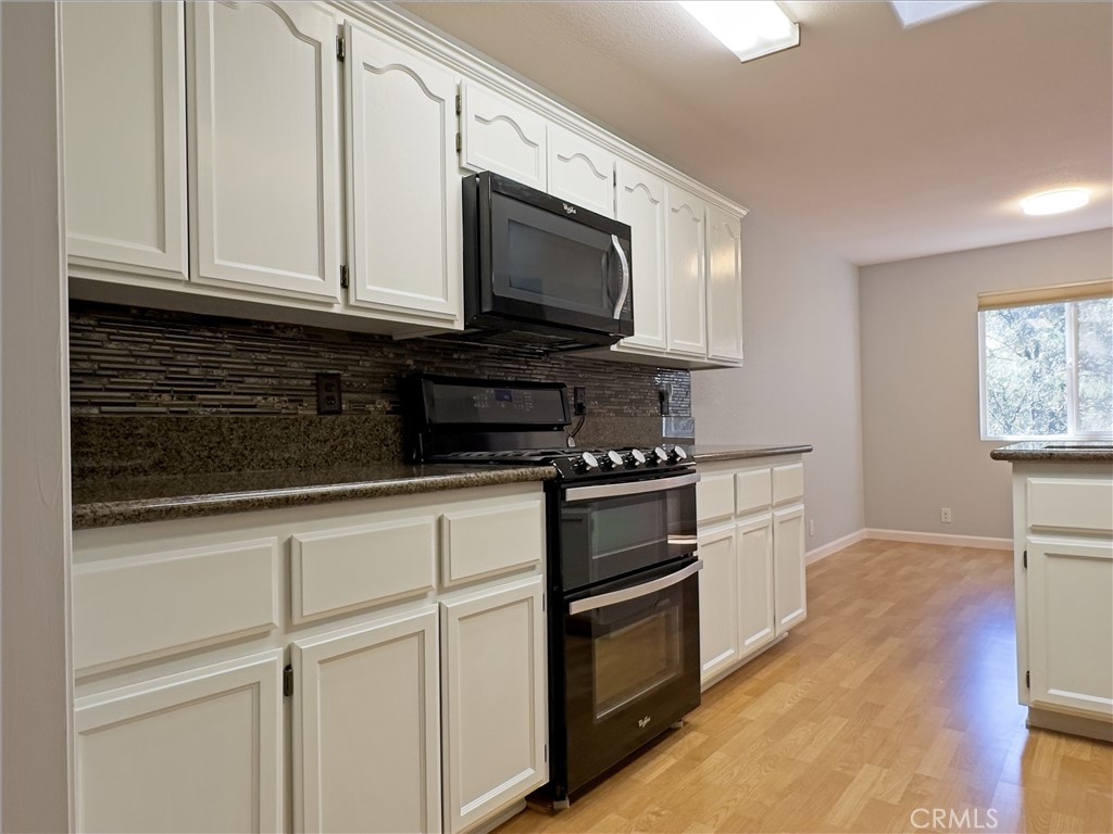 14279 Carnegie Road Magalia, CA 95954 - Photo 10 of 38 a kitchen with stainless steel appliances granite countertop a stove a microwave and a white cabinets