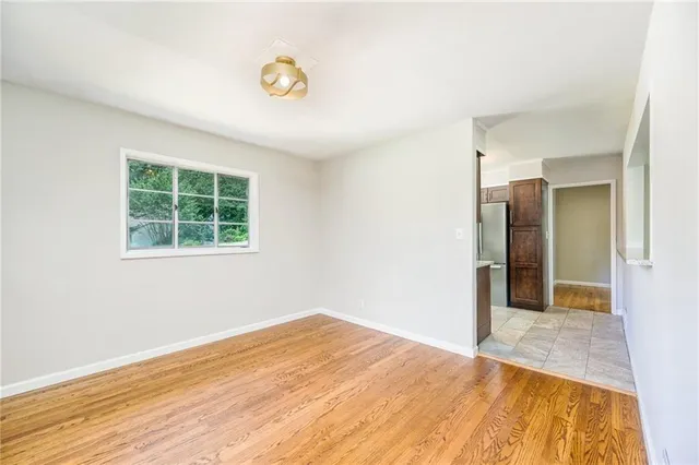 a view of empty room with wooden floor and window