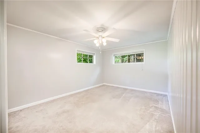 an empty room with windows and chandelier fan